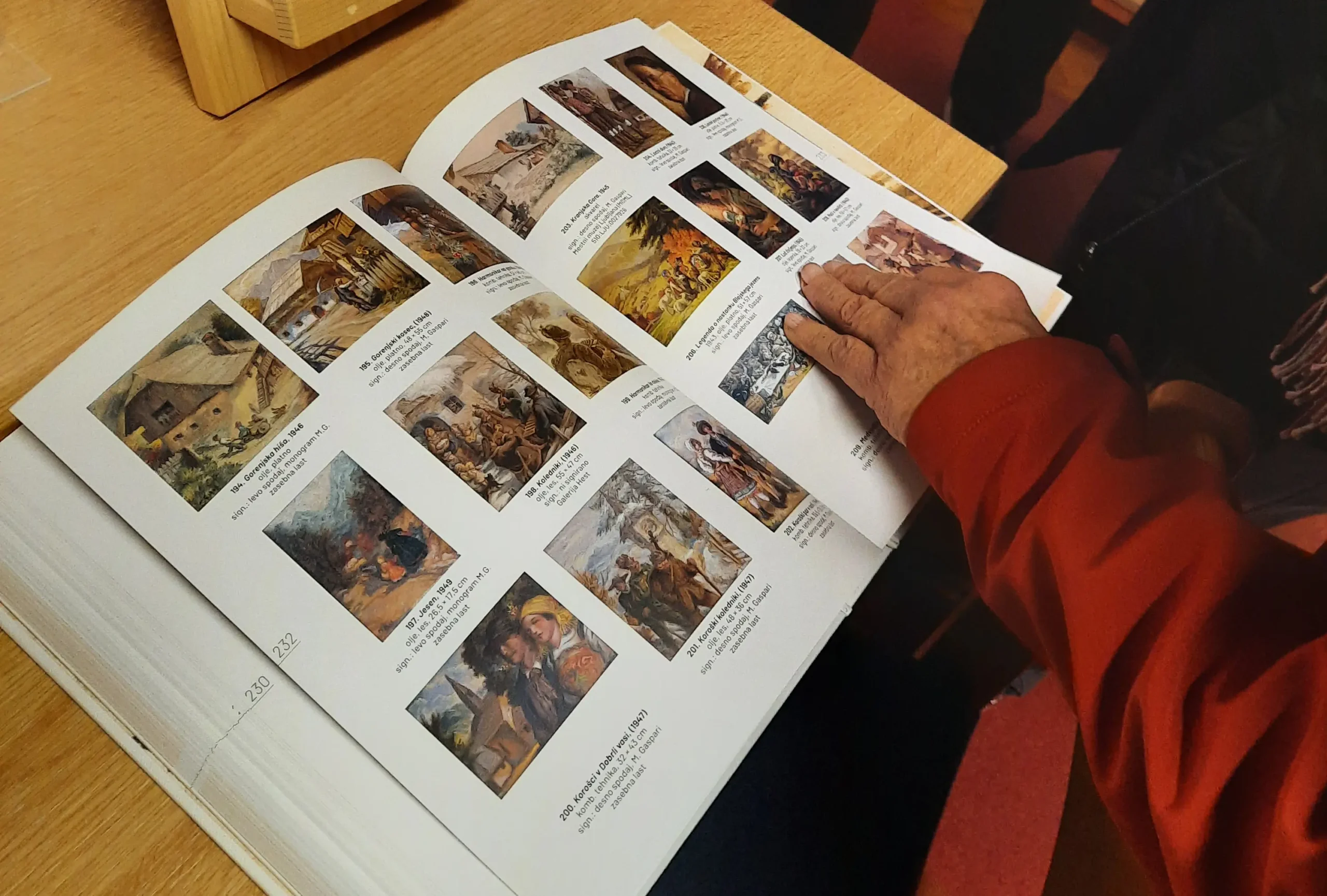 Odprta monografija o Maksimu Gaspariju z reprodukcijami umetniških del in knjiga Poezije bratov Gaspari na lesenem stojalu